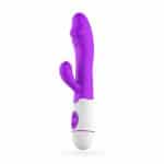 vibrador de doble estimulación con la base en blanco y el resto en púrpura. Un extremo con forma de glande