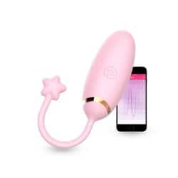 huevito vibrador rosa redondeado con una estrella de recuperador y un celular de fondo